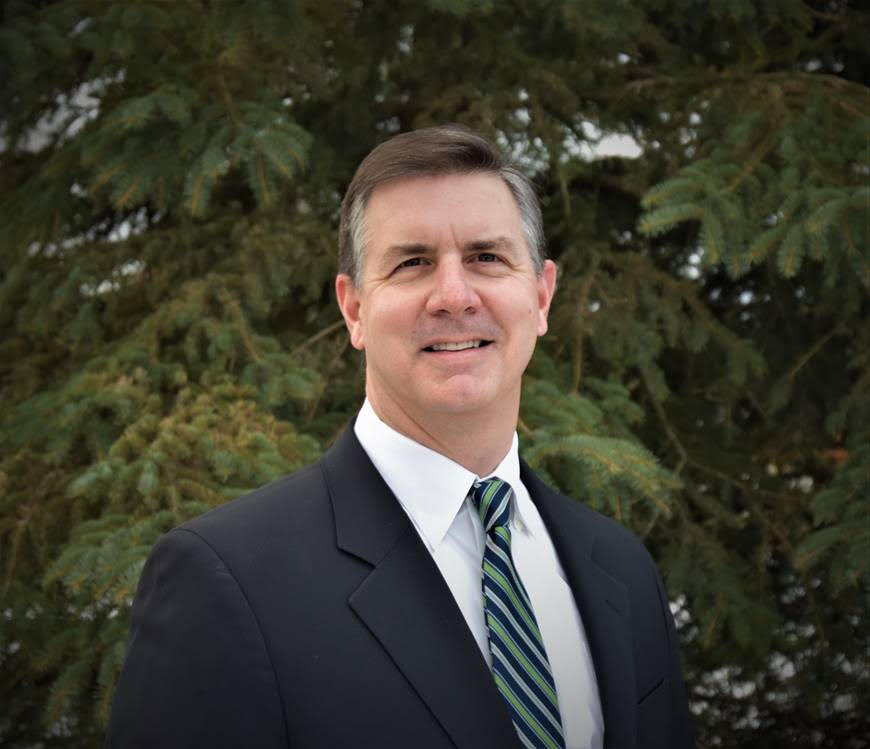 Business professional in suit with green trees